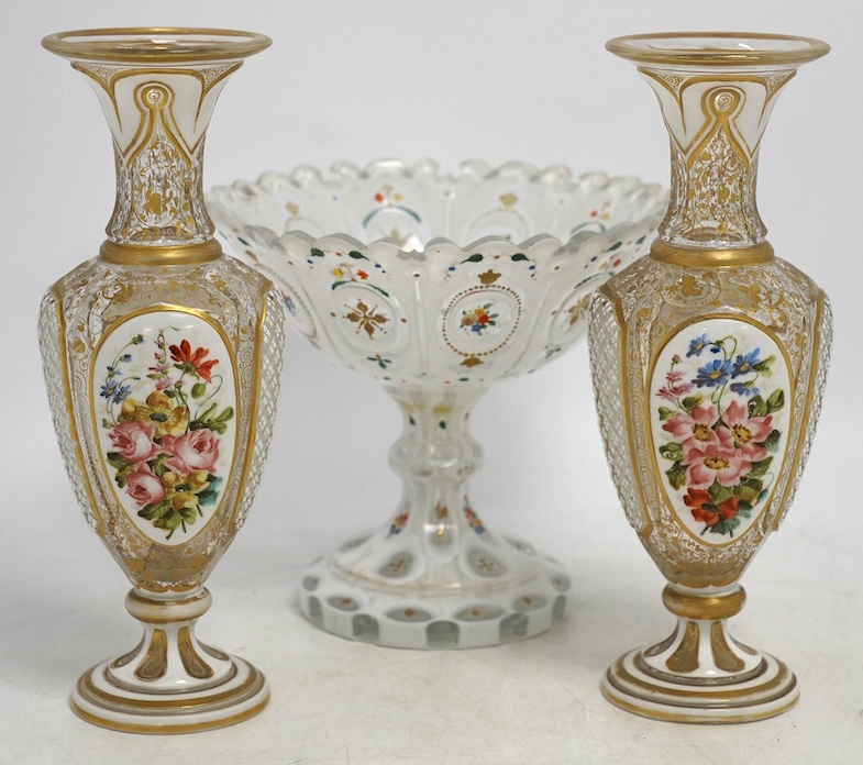 A pair of late 19th century Bohemian enamelled overlaid glass vases, and a similar overlaid glass comport. Condition - vases fair; comport poor